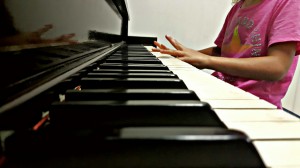 An incoming first grader takes piano lessons through the summer.