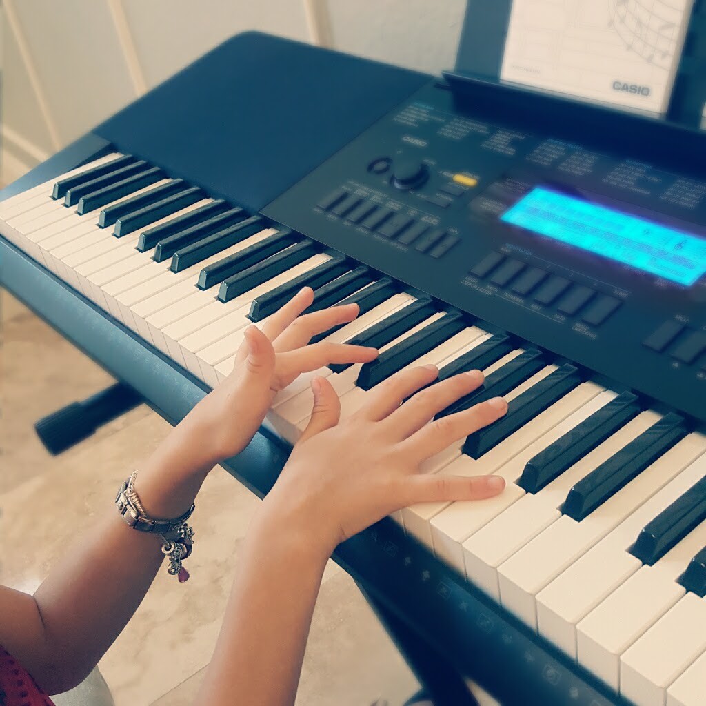 A young student at her very first piano lesson.